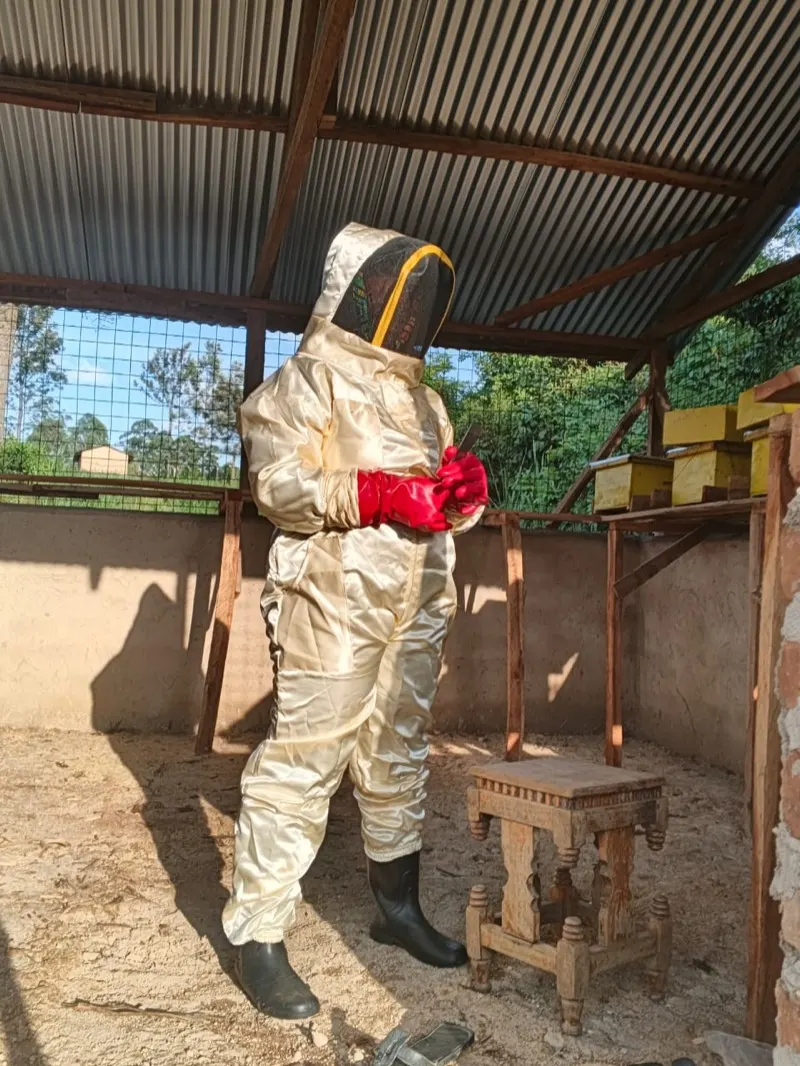A Waweza staff member in a bee suit at the bee house